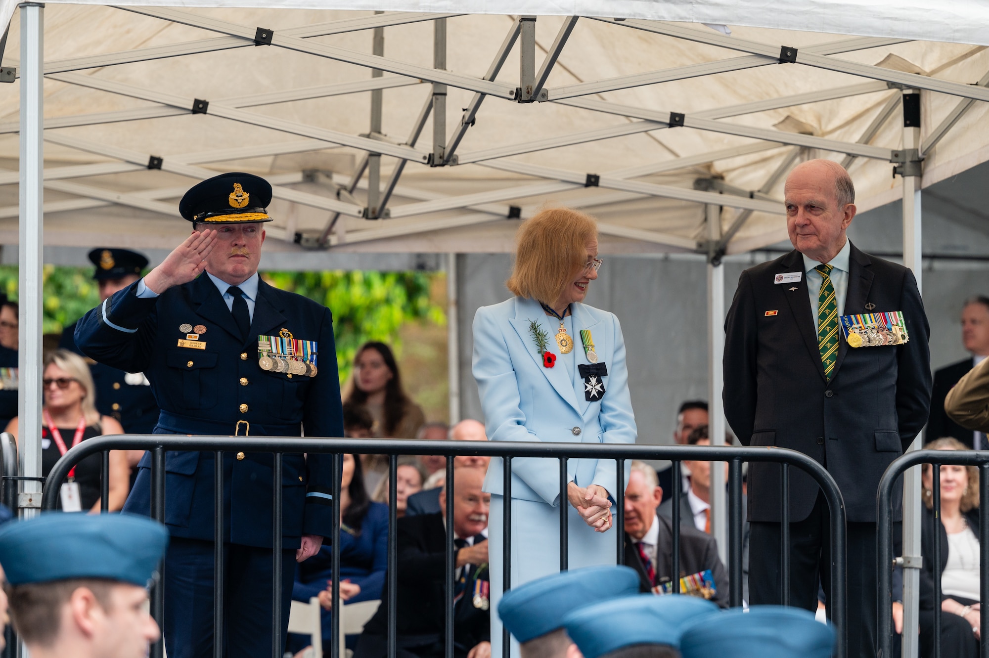 Royal Australian Air Force Air Commodore Robert Graham, Combat Support Group commander and Mr. Kerry Gallagher, Brisbane Australian and New Zealand Army Corps Day Parade Committee chair member, pay respect to passing service members during the ANZAC Day march in Brisbane, Australia.