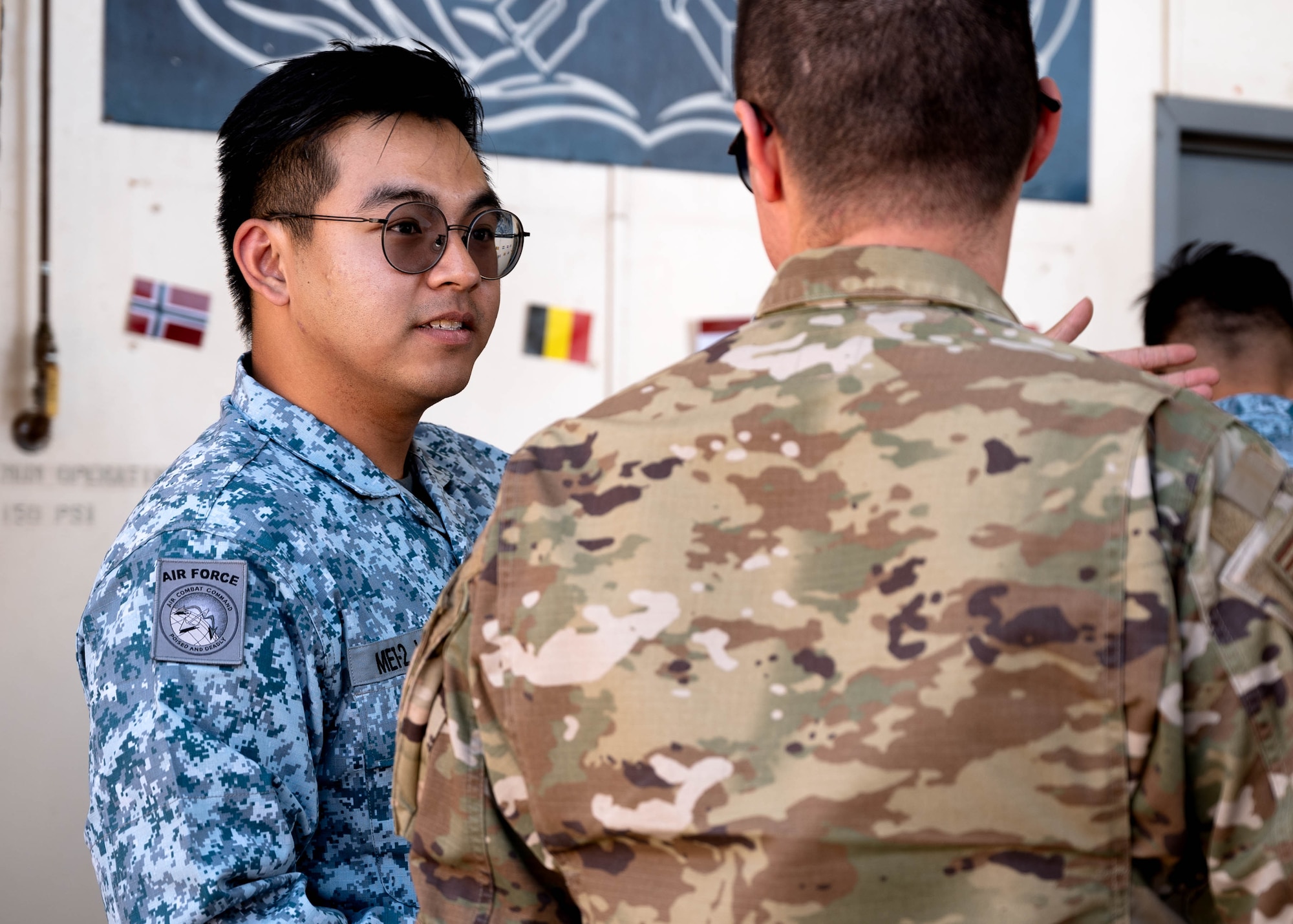 Republic of Singapore Air Force Military Expert 1-2 Jun Wei Yap, 425th Fighter Squadron maintainer, directs guests during Allies and Partners Day