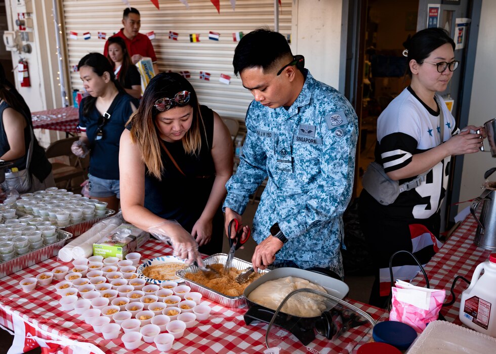 Republic of Singapore Air Force military personnel and their families prepare muah chee, a peanut butter mochi-like snack during Allies and Partners Day