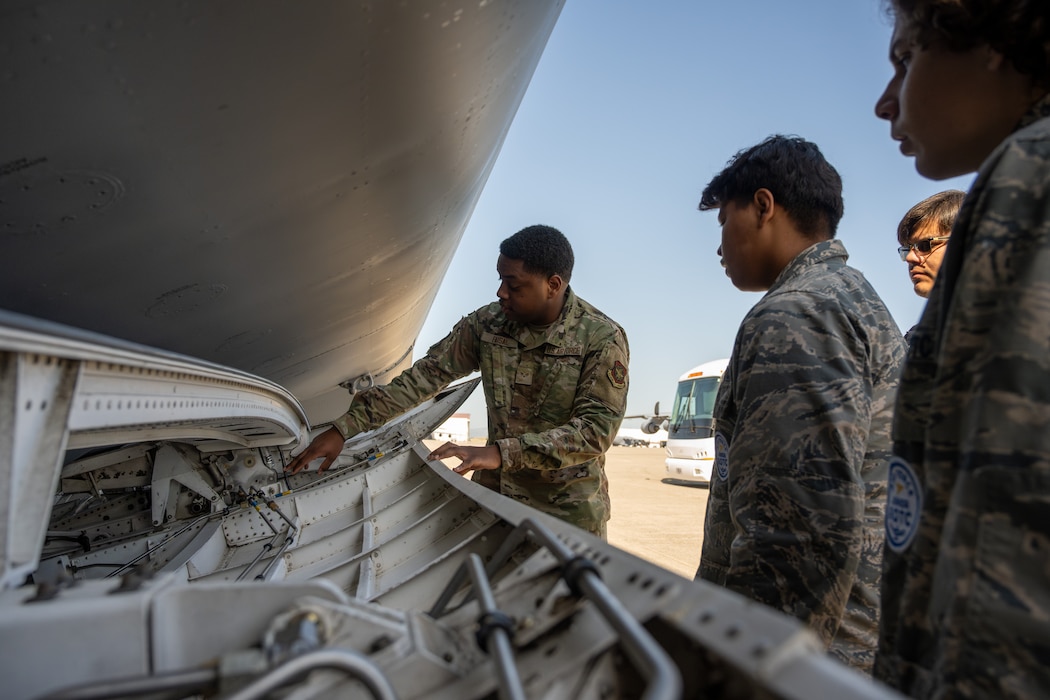 An Airman shows JROTC cadets a US Air Force C5
