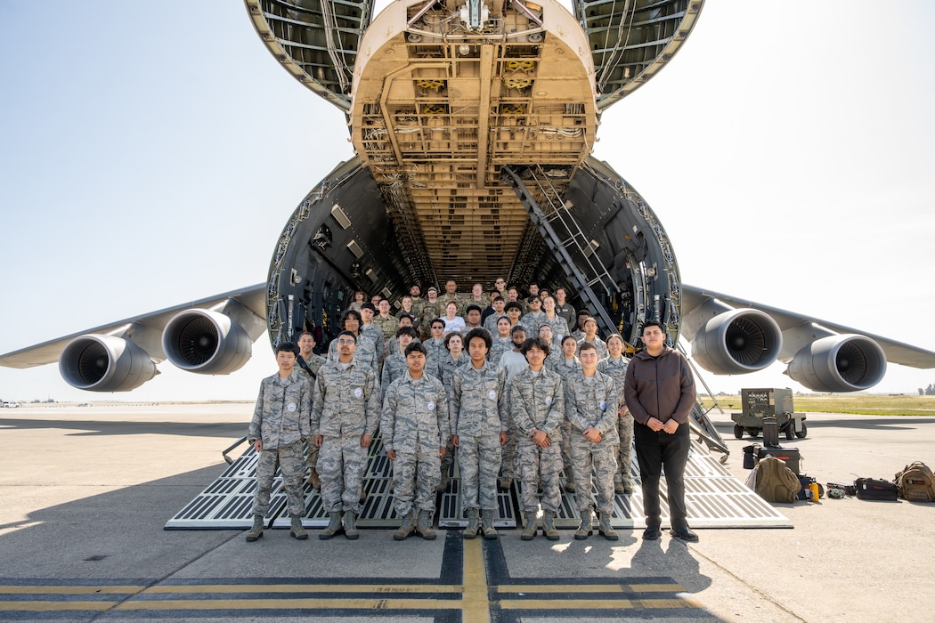 JROTC stand with Airman in front of a US Air Force C5