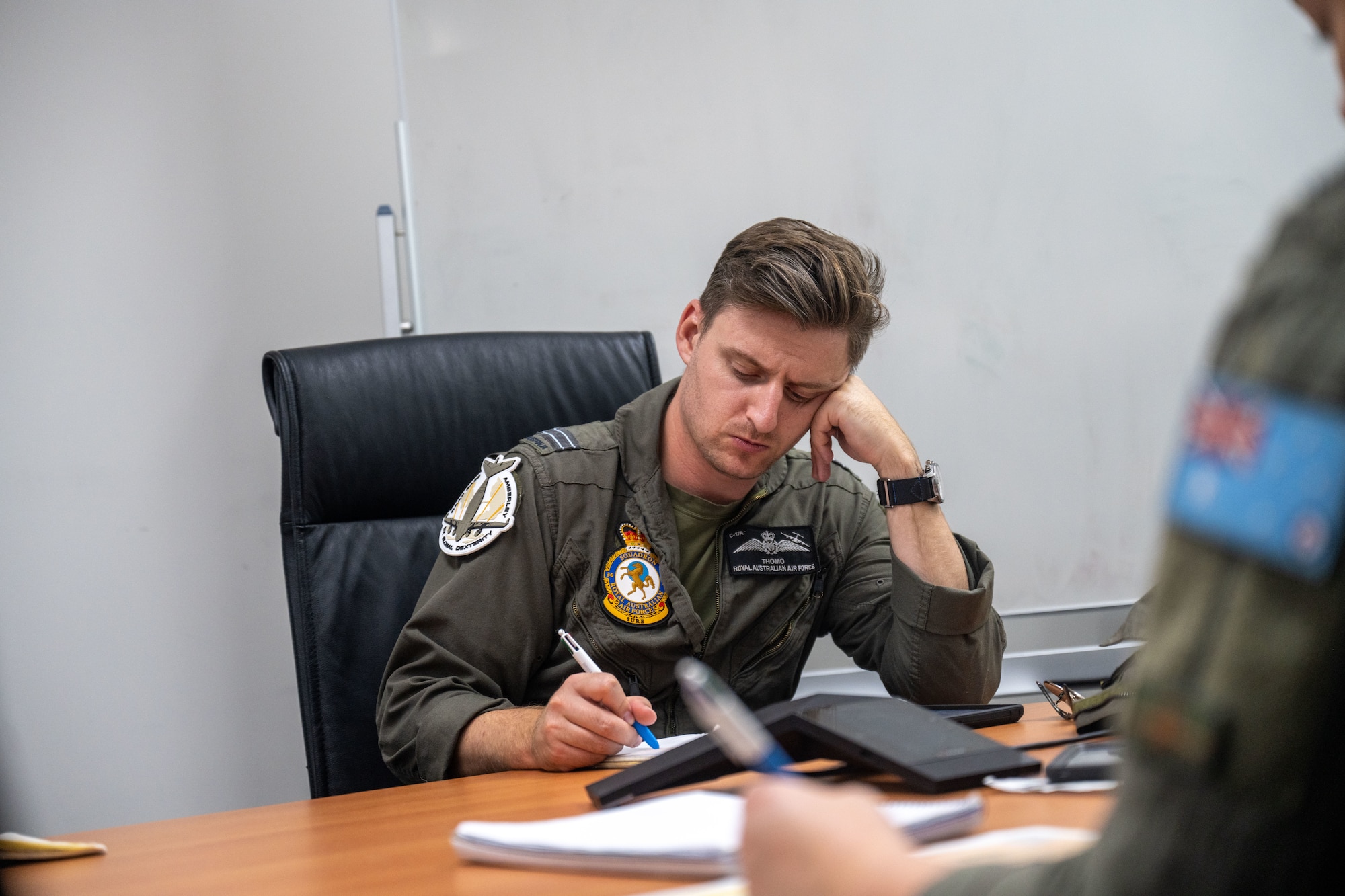 Royal Australian Air Force pilots sit around a conference table and plan future operations in Brisbane, Queensland, Australia.