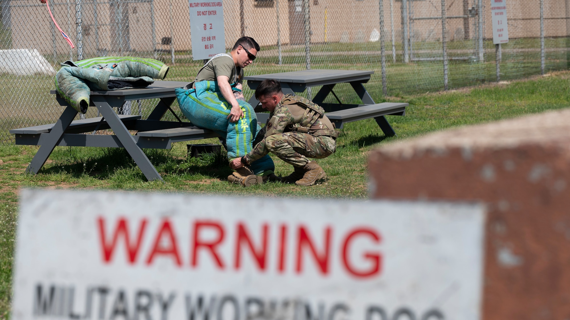 U.S. Air Force Staff Sgt. Tyler Cisneros, left, and Senior Airman Brandon Duncan, both military working dog handlers assigned to the 51st Security Forces Squadron prepare for MWD bite training at Osan Air Base, Republic of Korea, April 30, 2025. Dog bite suits are important because they allow handlers and decoys to safely conduct realistic training scenarios that teach the dogs controlled aggression, targeting, and bite strength without causing injury to humans. MWD bite training teaches military working dogs to use force when commanded to subdue and apprehend threats. (U.S. Air Force photo by Senior Airman Rome Bowermaster)