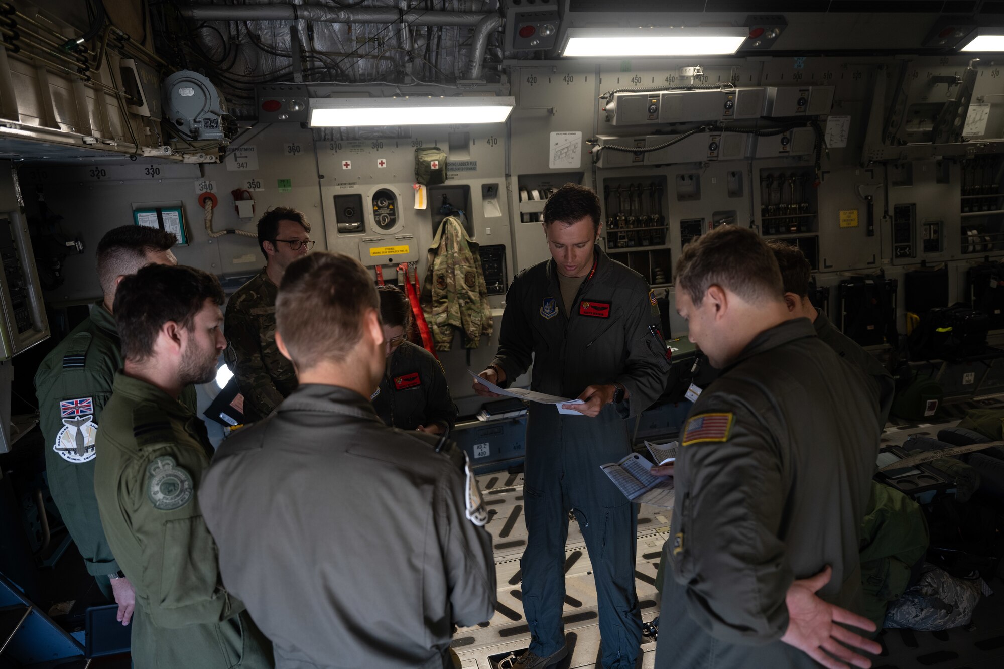 Aircrew from a variety of nations go over flight plans before taking off on a C-17.