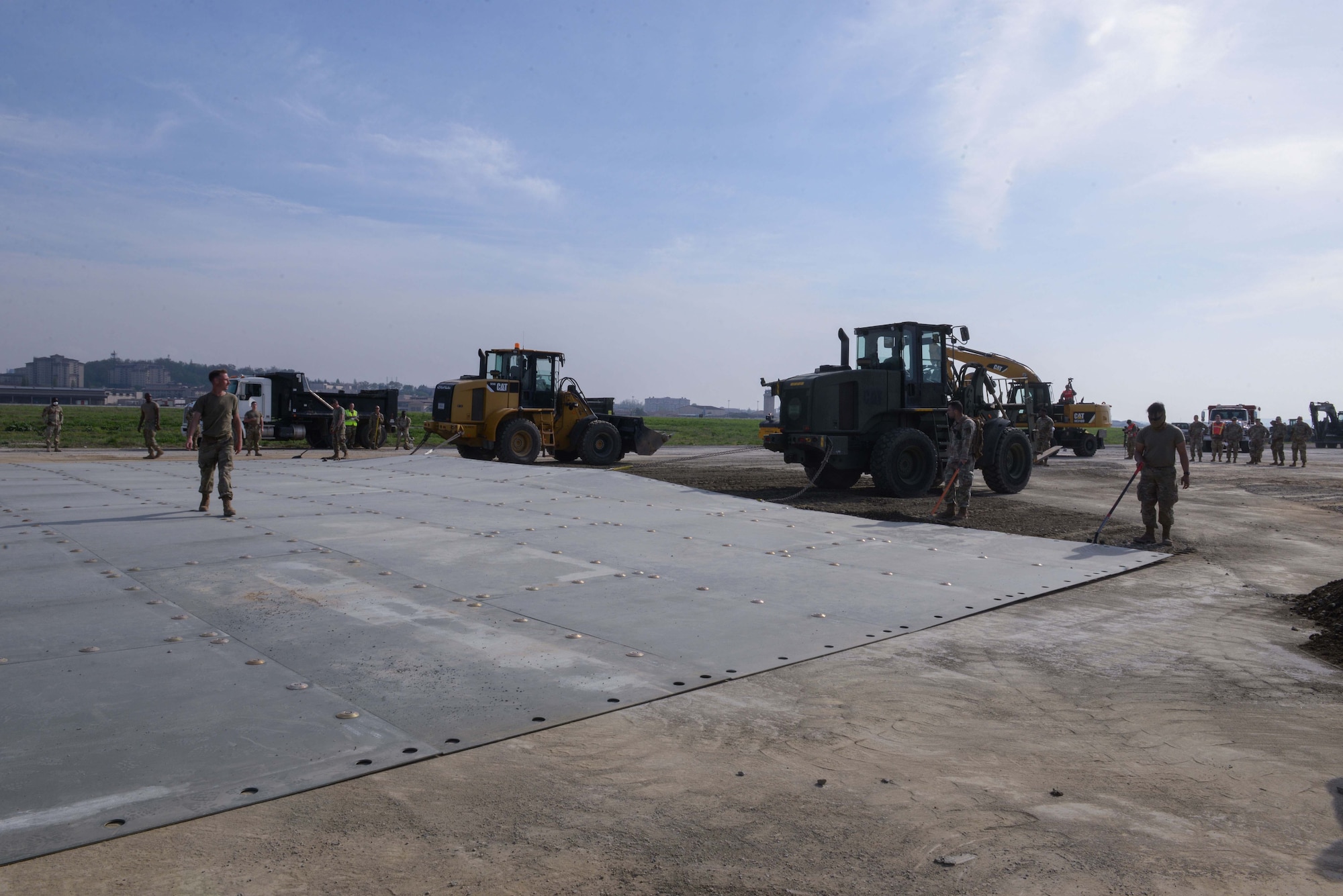 U.S. Air Force Airmen assigned to the 51st Civil Engineer Squadron pull a fiber reinforced polymer mat over a large crater repair during IRON RADR at Osan Air Base, Republic of Korea, April 24, 2025. Rapid airfield damage repair is a process for repairing structural damage on airfields to restore combat airpower generation when needed. The metal blanket protects rocks and other foreign object debris from dislodging from the newly filled crater when aircraft use the airfield for takeoff. (U.S. Air Force photo by Staff Sgt. Kahdija Slaughter)