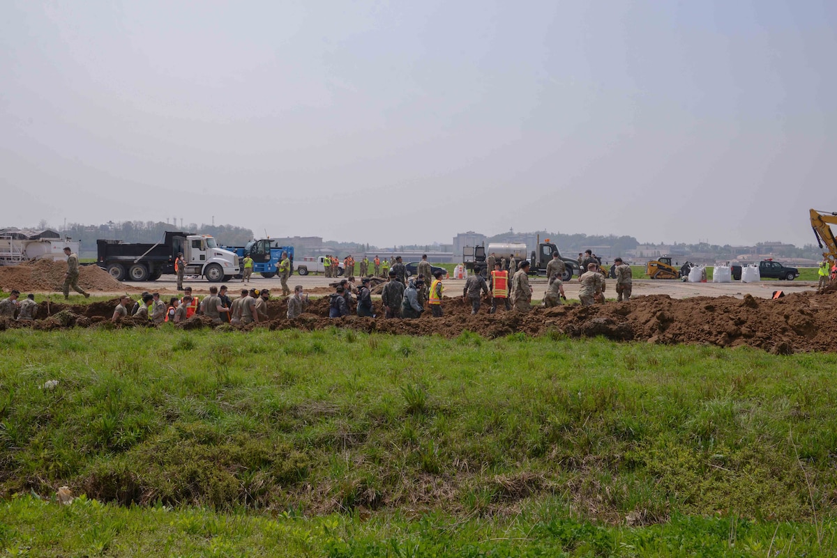 Members of the U.S. Air Force, U.S. Army, Republic of Korea Army, and ROK Air Force exit a berm ditch after a simulated air attack during exercise IRON RADR at Osan Air Base, Republic of Korea, April 24, 2025. Rapid airfield damage repair is a process for repairing structural damage on airfields to restore combat airpower generation. The team of civil engineers, logistics technicians, vehicle maintainers, explosive ordnance technicians and emergency medical responders worked together to repair craters in a damaged airfield pad enhancing U.S.-ROK partnership and displaying interoperability in action. (U.S. Air Force photo by Staff Sgt. Kahdija Slaughter