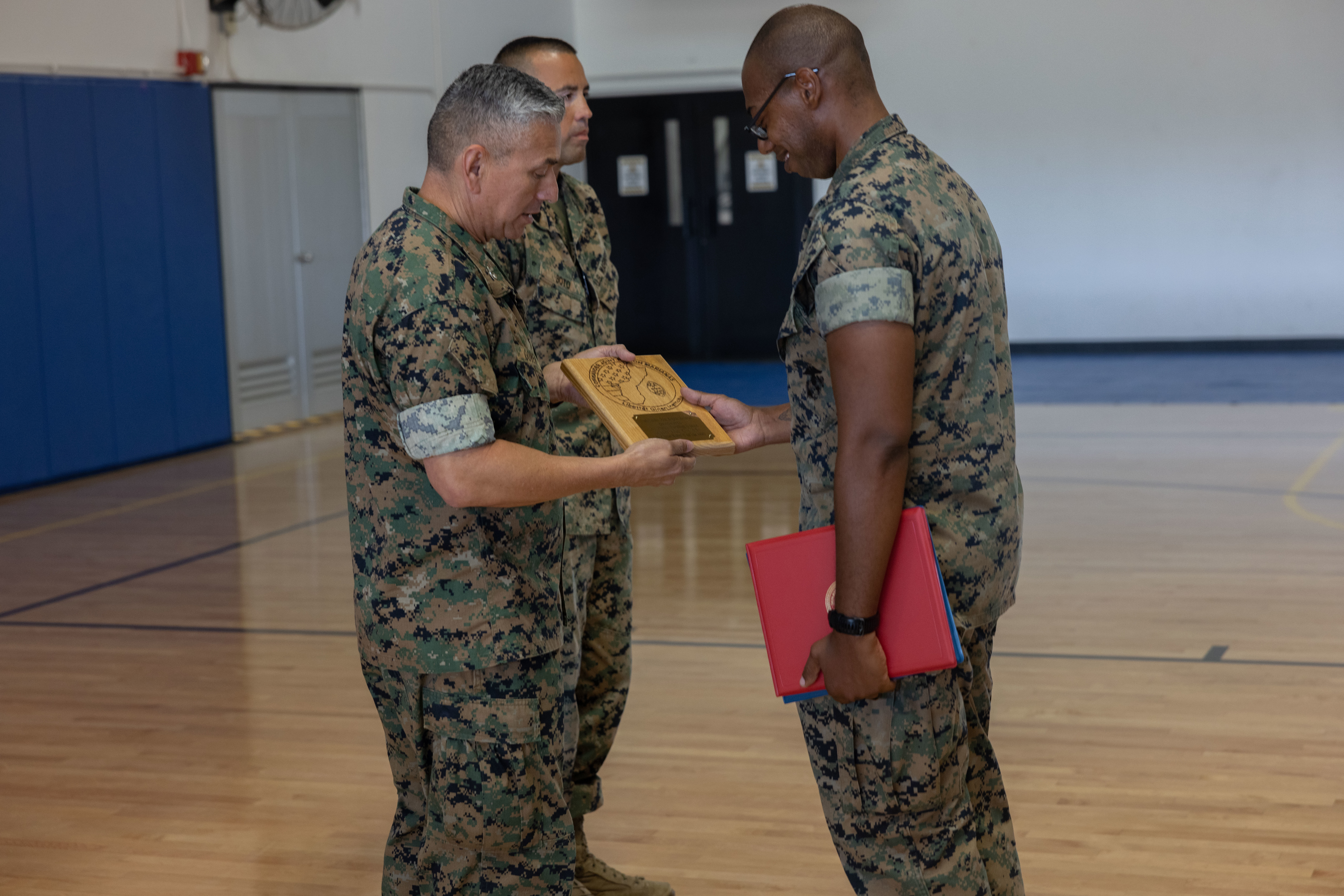 U.S. Marine Corps Staff Sgt. Marcellous Dixon, training chief, Marine Corps Base Camp Blaz, is given a plaque as a sign of appreciation during an award ceremony at MCB Camp Blaz, Guam, April 25, 2025. Dixon received a plaque for his outstanding accomplishments while serving at MCB Camp Blaz. (U.S. Marine Corps photo by Lance Cpl. Tanner Currin)