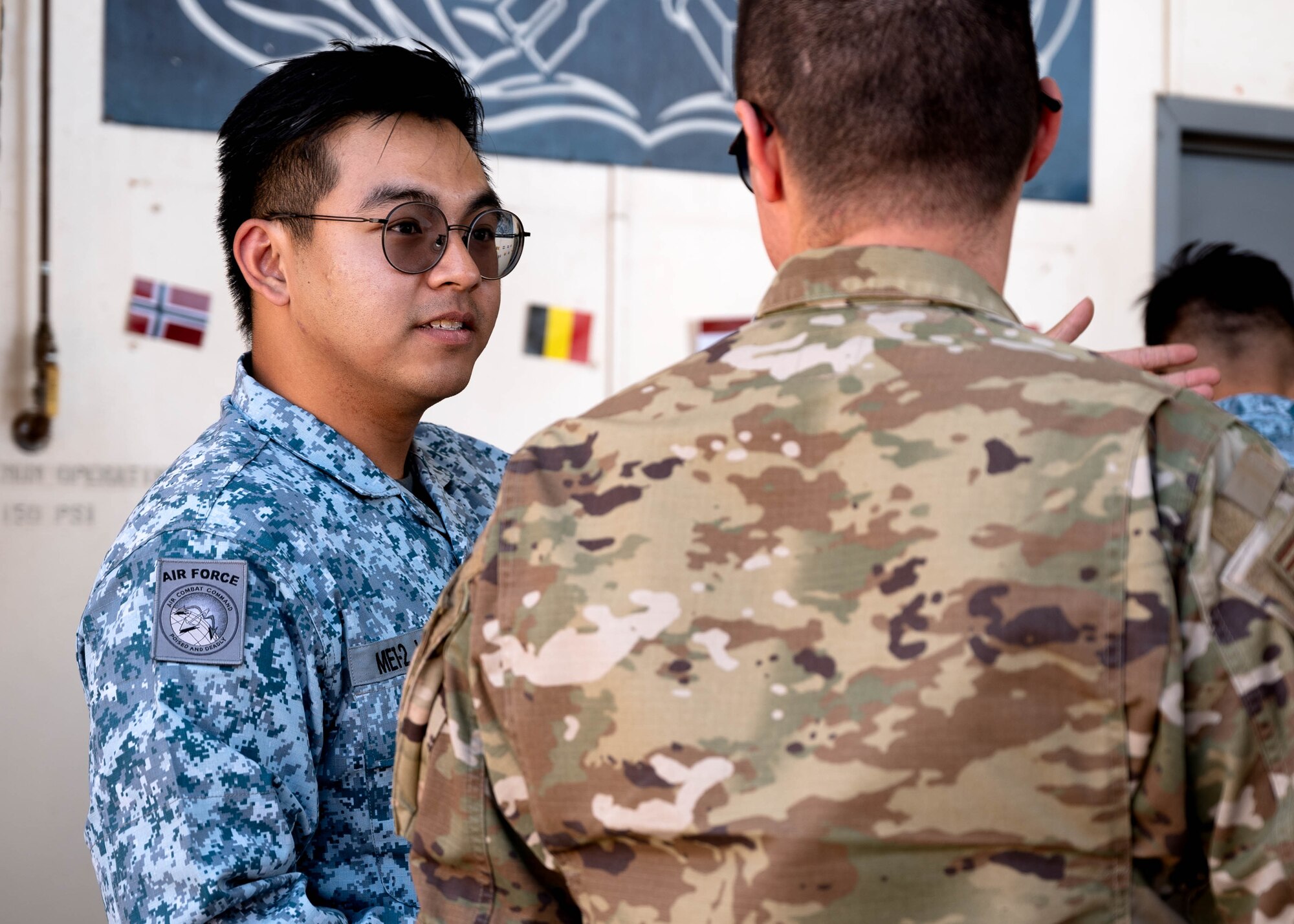 Republic of Singapore Air Force Military Expert 1-2 Jun Wei Yap, 425th Fighter Squadron maintainer, directs guests during Allies and Partners Day