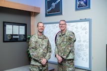 Two men in uniform stand next to each other