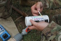 Sgt. Jessica Shields, a water purification specialist with the 935th Aviation Support Battalion, Missouri Army National Guard, checks the chlorine levels of the water meant for cooking and cleaning laundry during TRADEWINDS 25 exercise at Teteron Bay, Trinidad and Tobago, April 27, 2025.