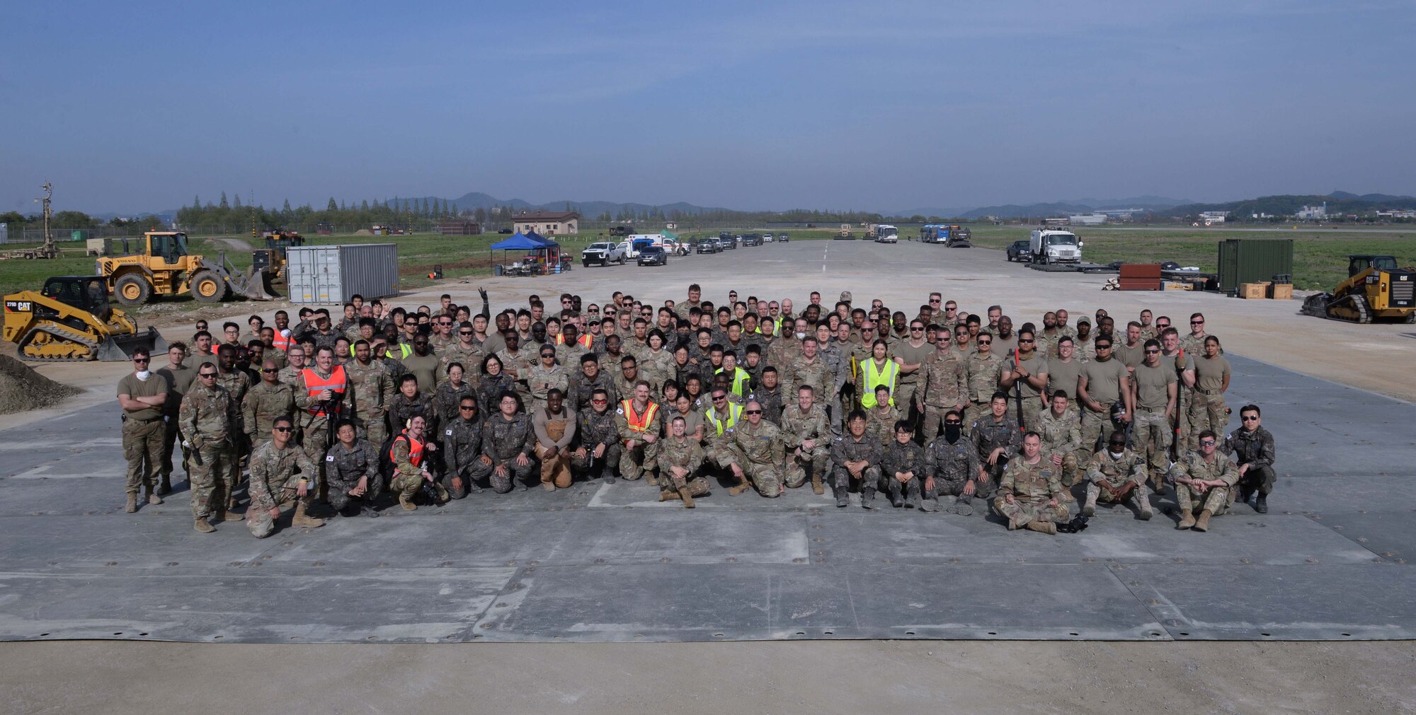 Members of the U.S. Air Force, U.S. Army, Republic of Korea Army, and ROK Air Force pose for a photo during exercise IRON RADR at Osan Air Base, Republic of Korea, April 24, 2025. The team of civil engineers, logistics technicians, vehicle maintainers, explosive ordnance technicians and emergency medical responders worked together to repair craters in a damaged airfield pad enhancing U.S.-ROK partnership and displaying interoperability in action. (U.S. Air Force photo by Staff Sgt. Kahdija Slaughter)