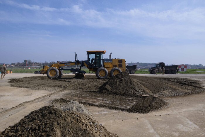 Members of the U.S. Air Force, U.S. Army, Republic of Korea Air Force and ROK Army level the dirt recently packed into a large crater in an airfield pad during IRON RADR at Osan Air Base, Republic of Korea, April 24, 2025. IRON RADR is the first complex, joint and combined exercise on Osan AB that tests, evaluates and prepares civil engineers to safely conduct rapid airfield damage repair operations in a simulated contingency environment. One large and six small craters were repaired in less than eight hours; enhancing the U.S.-ROK partnership, ‘Fight Tonight’ mission capabilities, and interoperability for contingency operating bases across the Korean peninsula. (U.S. Air Force photo by Staff Sgt. Kahdija Slaughter)