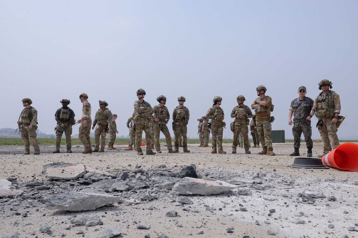 Members of the U.S. Air Force, U.S. Army, U.S. Marine Corps, and Republic of Korea Air Force examine small craters and foreign object debris created by the 51st Civil Engineer Squadron explosive ordnance disposal flight during a joint and combined EOD training at Osan Air Base, Republic of Korea, April 18, 2025. The training created an instructional and hands-on environment to learn and execute tactics, techniques, and procedures when creating explosive ordnances. The detonations prepared during the training laid the realistic foundation needed for a complex rapid airfield damage repair exercise called IRON RADR. (U.S. Air Force photo by Staff Sgt. Kahdija Slaughter)