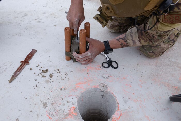 U.S. Air Force Tech. Sgt. Gerardo Perez, 51st Civil Engineer Squadron explosive ordnance disposal technician, carefully creates a charge hole in a C4, TNT, and dynamite ordnance at Osan Air Base, Republic of Korea, April 18, 2025. Several explosives were placed in concrete and asphalt holes, creating a realistically damaged airfield for the first complex, joint and combined IRON RADR exercise. The rapid airfield damage repair mission encompasses advanced pavement repair techniques and strategies that support airfield operations in degraded and contingency conditions, allowing swift restoration of combat airpower generation capabilities no matter the warfighting landscape. (U.S. Air Force photo by Staff Sgt. Kahdija Slaughter)