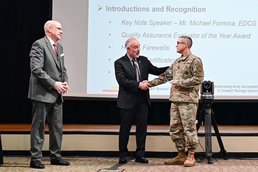 Dr. John Plifka, U.S. Army Training and Doctrine Command (TRADOC) quality assurance director (left), and Michael Formica, Executive Deputy to the TRADOC Commanding General, present an award to Sgt. 1st Class Gerald Funk (right) as he is named the TRADOC quality assurance evaluator of the year at a U.S. Army quality assurance program forum at Fort Eustis, Va. March 4, 2025. (Courtesy photo)
