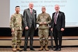 U.S. Army Sgt. Maj. Andy Yoshimura, U.S. Army Training and Doctrine Command quality assurance evaluator Sergeant Major (left), Dr. John Plifka, TRADOC quality assurance director, Sgt. 1st Class Gerald Funk, Quality Assurance Evaluator of the Year, and Michael Formica, Executive Deputy to the TRADOC Commanding General, stand before attendees of the inaugural U.S. Army quality assurance program forum as Funk is named the quality assurance evaluator of the year at Fort Eustis, Va. March 4, 2025. (Courtesy photo)