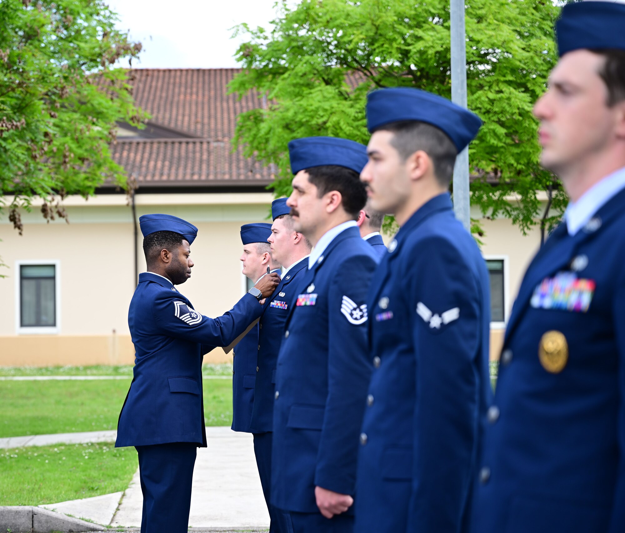 U.S. Air Force senior enlisted leader fixes tie for an Airman.