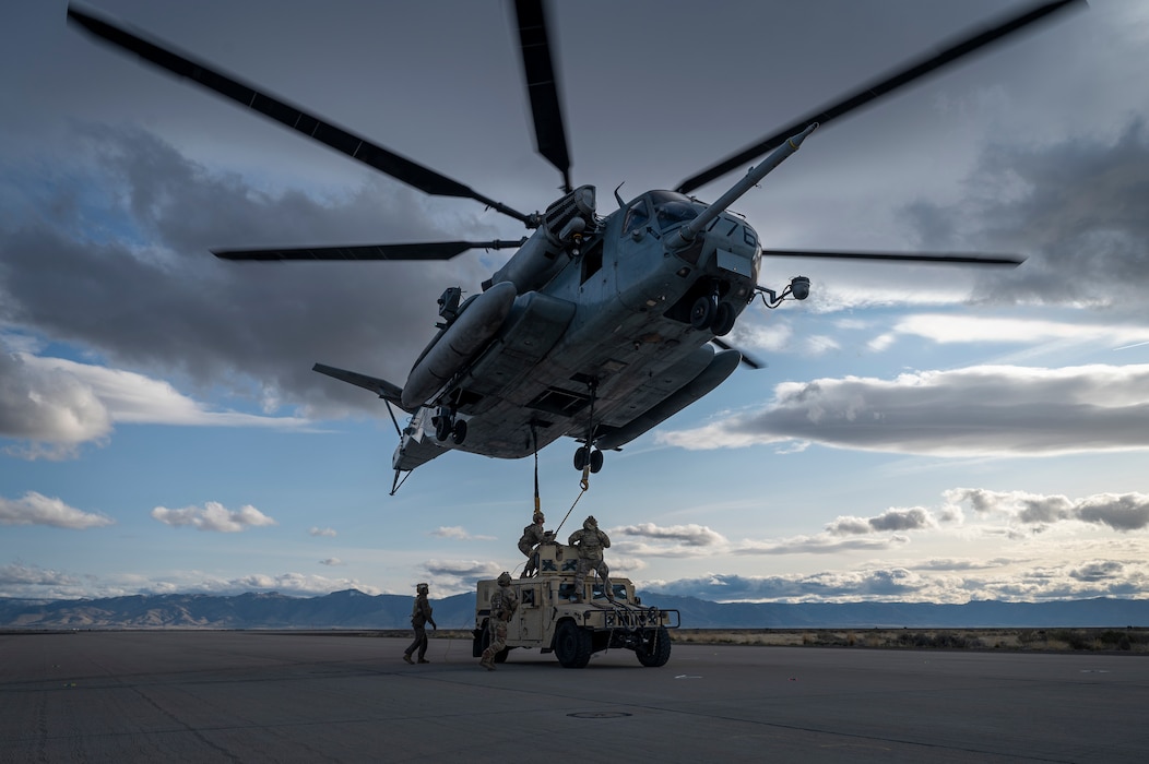 Airmen slinging a vehicle to a CH-53E