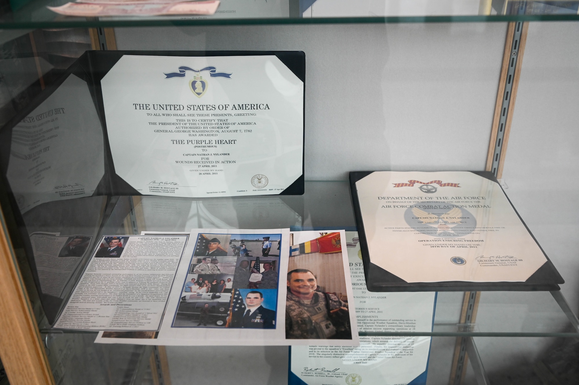 Part of a display dedicated to Capt. Nathan Nylander, a weather officer who was assigned to the 25th Operational Weather Squadron at Davis-Monthan Air Force Base, Arizona, is shown at the 557th Weather Wing atrium on Offutt Air Force Base, Nebraska, April 25, 2025. Nylander was killed with eight others during a shooting that occurred at Kabul International Airport on April 27, 2011. (U.S. Air Force photo by Daniel Martinez)
