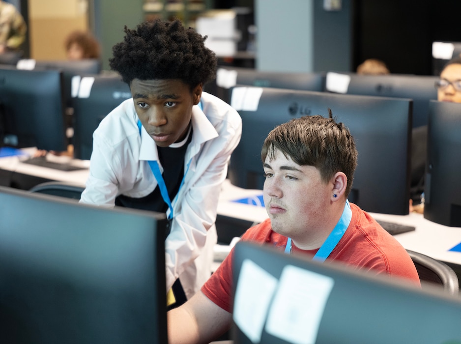 Two boys are looking at a computer screen.