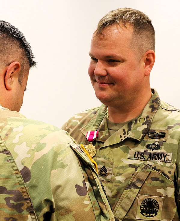 Col. Shawn Nokes, the Commander of the 129th Regiment (Regional Training Institute) pins the Meritorious Service Medal on Sgt. 1st Class Sean Fortune.