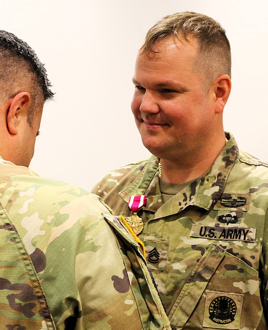 Col. Shawn Nokes, the Commander of the 129th Regiment (Regional Training Institute) pins the Meritorious Service Medal on Sgt. 1st Class Sean Fortune.