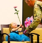 Sgt. 1st Class Sean Fortune gives his 2-year-old daughter, Savannah, a Disney Little Princess toy while she shows him a flower during his retirement ceremony.