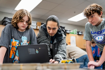 True Soria, a computer scientist at the Naval Surface Warfare Center Dahlgren Division (NSWCDD), mentors students at King George Middle School during the Robotics Week. This program is part of NSWCDD's in-classroom NSWCDD K-12 STEM Outreach Program initiatives, which aim to inspire local youth to become the next generation of scientists and engineers. (Dorina Watermolen/NSWCDD photo)