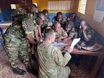 U.S. Army Sgt. 1st Class Shane Mills, readiness non-commissioned officer for the 246th Transportation Battalion, Michigan National Guard, discusses U.S. Army fleet management documentation processes with vehicle drivers from the Republic of Sierra Leone Armed Forces (RSLAF), April 17, 2025, at the RSLAF Joint Logistics Unit in the Murray Town district of Freetown, Sierra Leone.