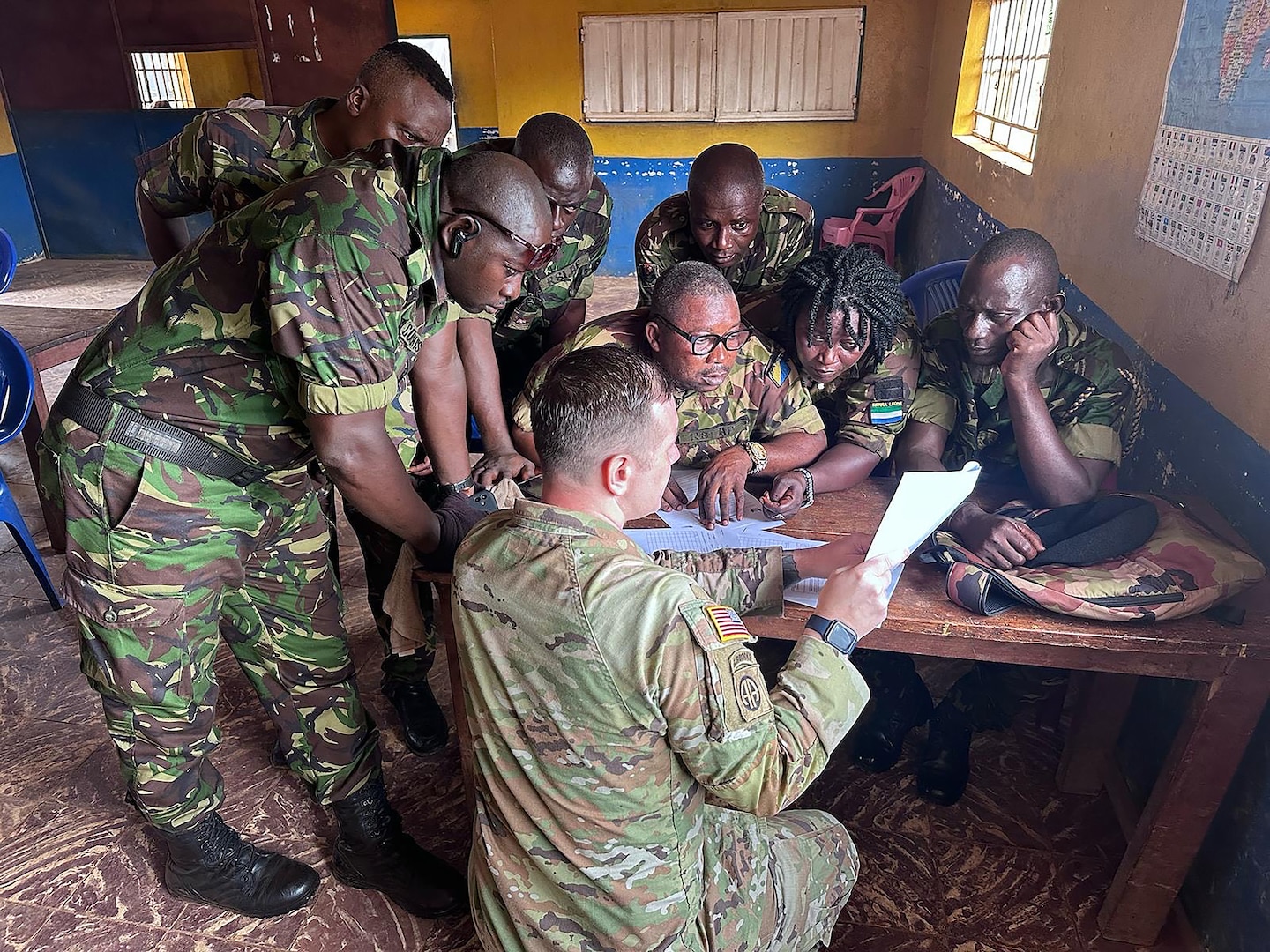 U.S. Army Sgt. 1st Class Shane Mills, readiness non-commissioned officer for the 246th Transportation Battalion, Michigan National Guard, discusses U.S. Army fleet management documentation processes with vehicle drivers from the Republic of Sierra Leone Armed Forces (RSLAF), April 17, 2025, at the RSLAF Joint Logistics Unit in the Murray Town district of Freetown, Sierra Leone.
