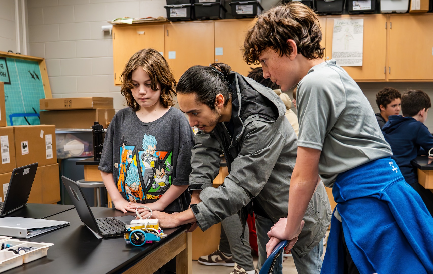 True Soria, a computer scientist at the Naval Surface Warfare Center Dahlgren Division (NSWCDD), mentors students at King George Middle School during Robotics Week. This program is part of NSWCDD's K-12 STEM Outreach initiatives, highlighting the organization's commitment to supporting in-class robotics workshops and lessons facilitated by NSWCDD engineers at local schools. (Dorina Watermolen/NSWCDD photo)