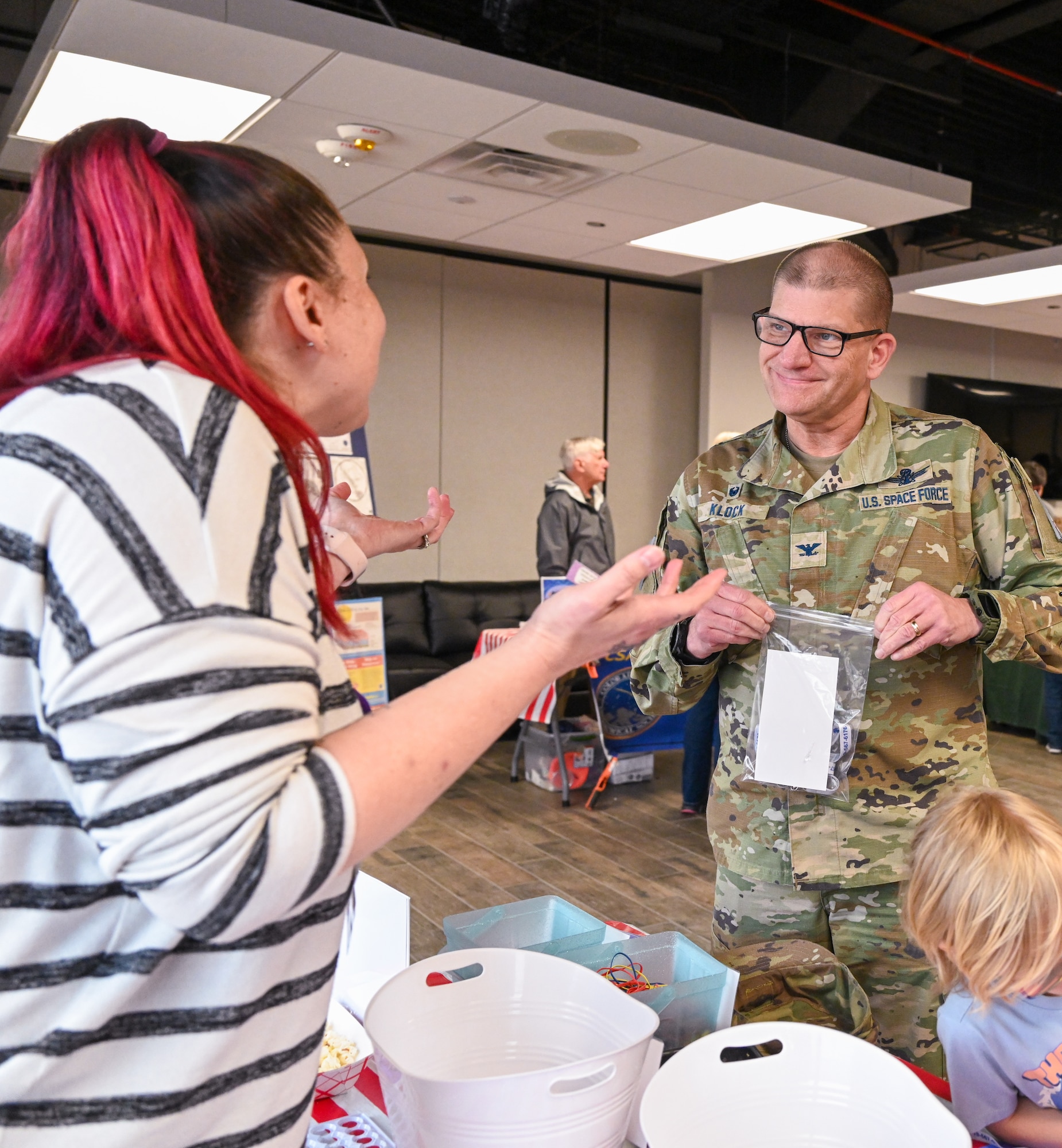 A military member speaks with someone at the STEM carnival event.