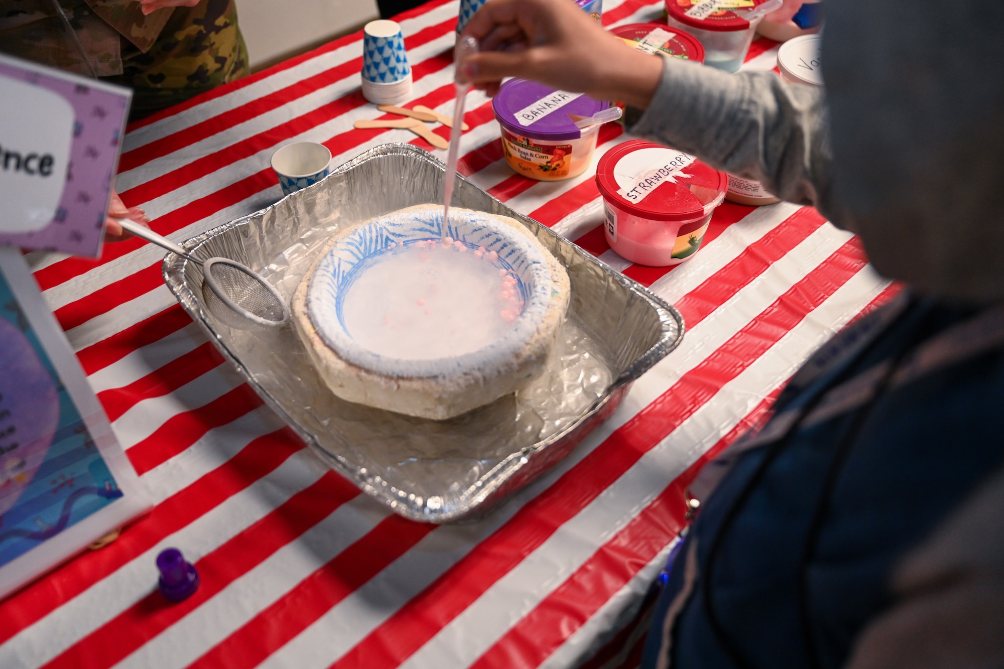 A child interacts with a science demonstration.