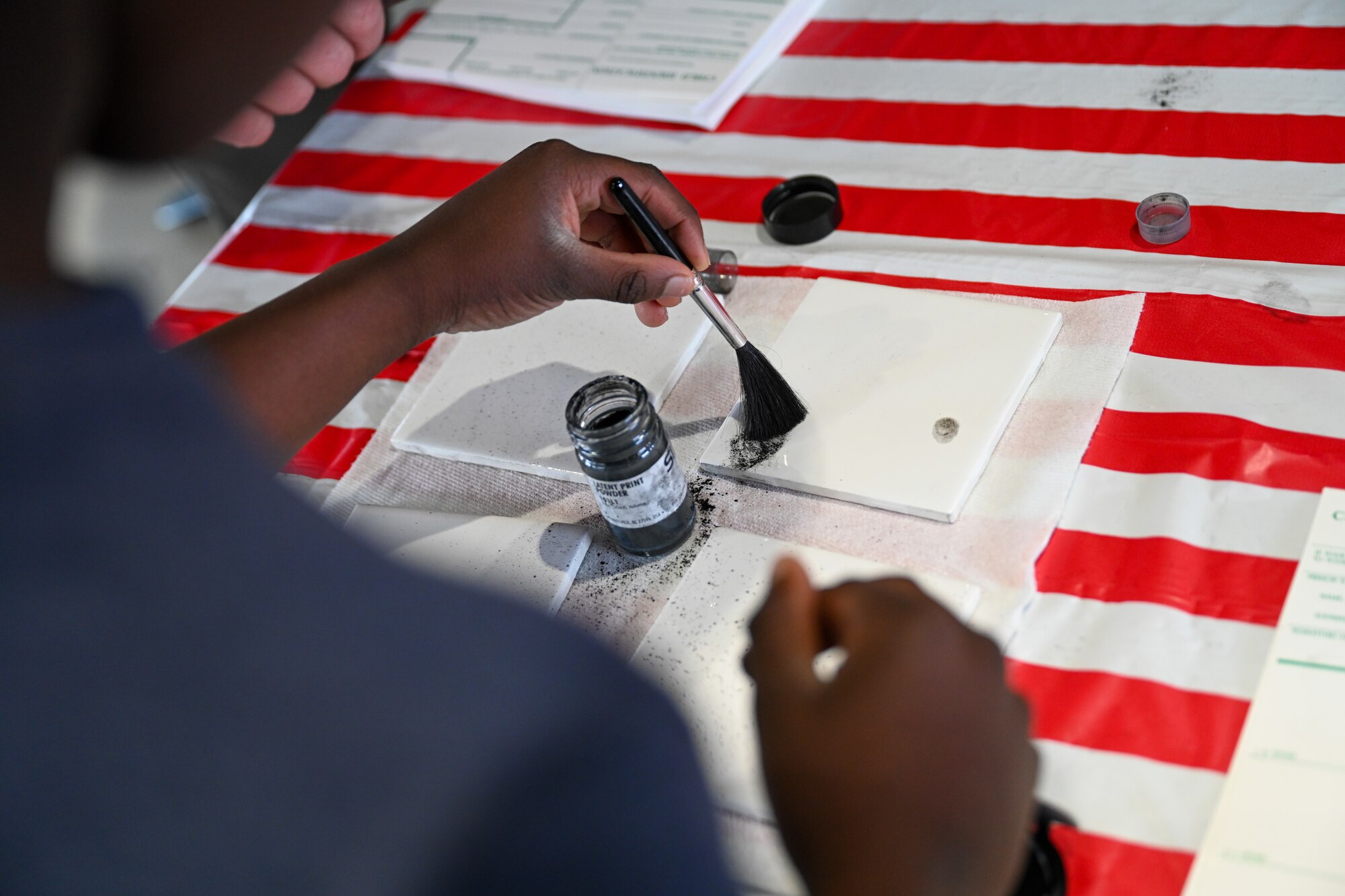 A child interacts with a fingerprint dusting demonstration