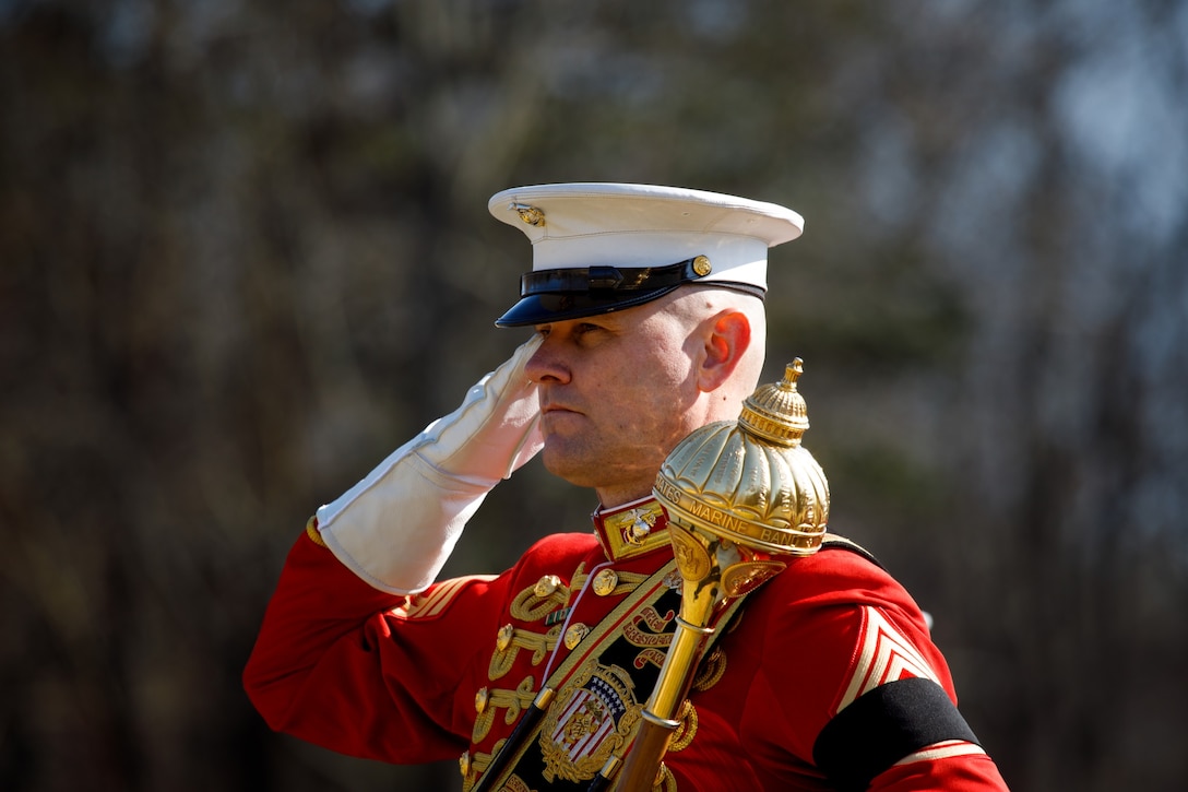 Master Gunnery Sgt. Duane King salutes during a funeral.