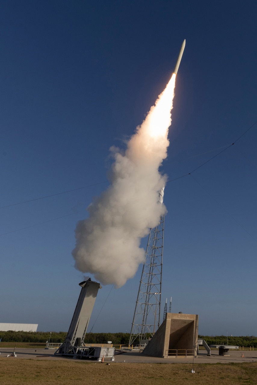 A missile leaves behind a trail of smoke and flames as it launches into the sky.
