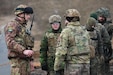Italian Army OR-8 Eduard Raduna (left,) Canadian Army Capt. Chelsea Stephen (center,) U.S. Army Capt. Mark Fisher, commander of Bravo company, 10th Brigade Engineer Battalion, 1st Armored Brigade Combat Team, 3rd Infantry Division, in support of Task Force Iron, discusses events during Verboom in Ādaži, Latvia, March 18, 2025. Exercise Verboom is a multinational training exercise with the goal of enhancing soldiers from varying nations interoperability and effectiveness on the removal of anti-personnel obstacles. Task Force Iron's mission is to engage in multinational training and exercises across the continent to increase lethality, while strengthening partnerships with our NATO allies and regional security partners. The task force provides combat-credible forces to V Corps, America’s only forward-deployed corps in Europe. (U.S. Army photo by Spc. Trevor Wilson)