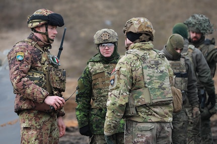 Italian Army OR-8 Eduard Raduna (left,) Canadian Army Capt. Chelsea Stephen (center,) U.S. Army Capt. Mark Fisher, commander of Bravo company, 10th Brigade Engineer Battalion, 1st Armored Brigade Combat Team, 3rd Infantry Division, in support of Task Force Iron, discusses events during Verboom in Ādaži, Latvia, March 18, 2025. Exercise Verboom is a multinational training exercise with the goal of enhancing soldiers from varying nations interoperability and effectiveness on the removal of anti-personnel obstacles. Task Force Iron's mission is to engage in multinational training and exercises across the continent to increase lethality, while strengthening partnerships with our NATO allies and regional security partners. The task force provides combat-credible forces to V Corps, America’s only forward-deployed corps in Europe. (U.S. Army photo by Spc. Trevor Wilson)