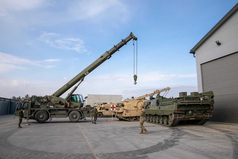 U.S. Army soldiers with Alpha Battery, 1st Battalion, 41st Field Artillery Regiment, and the Spanish Armed Forces work together to replace the engine on a U.S. M88A2 Hercules Armored Recovery Vehicle at Camp Adazi, Latvia, April 14, 2025. The Spanish Armed Forces assisted the U.S. with a Leopard 2ER Buffalo tracked recovery vehicle and a crane to replace an engine of an M88A2. V Corps and NATO Allies deter adversaries by demonstrating a combat-credible force through multinational training and exercises. (U.S. Army photo by Spc. Rachel Hall)