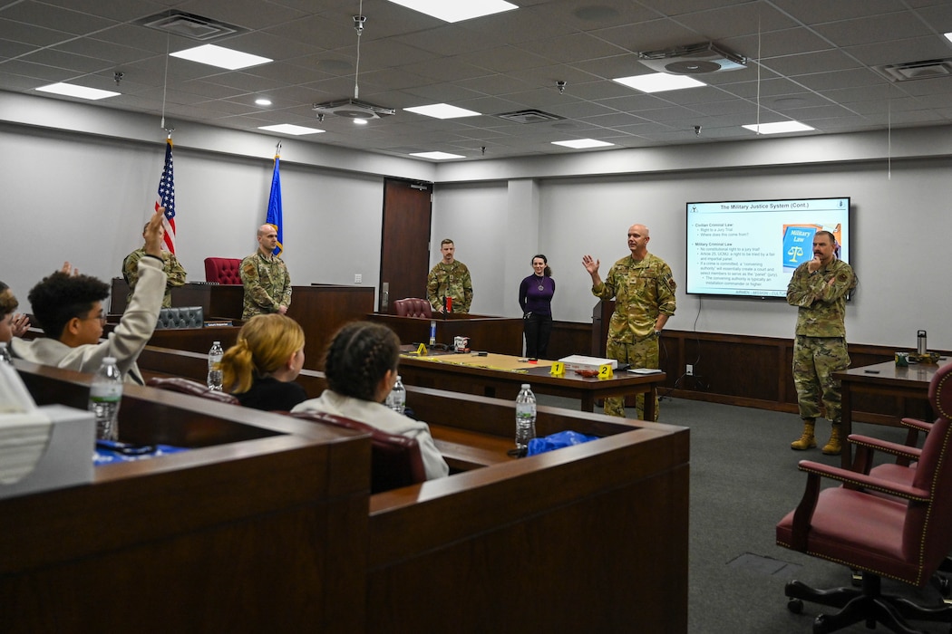 U.S. Air Force Col. Jeff Marshall, 97th Air Mobility Wing (AMW) commander, and Chief Master Sgt. Justin Brundage, 97th AMW command chief, answer questions from Altus Junior High School students during Law Day at Altus Air Force Base, Oklahoma, May 1, 2025. Marshall and Brundage welcomed the students as they arrived for the mock trial. (U.S. Air Force photo by Airman 1st Class Lauren Torres)