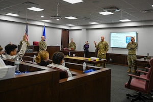 U.S. Air Force Col. Jeff Marshall, 97th Air Mobility Wing (AMW) commander, and Chief Master Sgt. Justin Brundage, 97th AMW command chief, answer questions from Altus Junior High School students during Law Day at Altus Air Force Base, Oklahoma, May 1, 2025. Marshall and Brundage welcomed the students as they arrived for the mock trial. (U.S. Air Force photo by Airman 1st Class Lauren Torres)