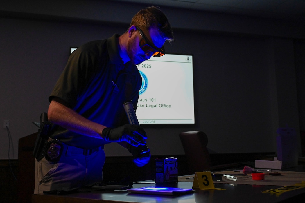 Special Agent Isaiah Moore, assigned to Air Force Office of Special Investigations detachment 422, shows Altus Junior High School students how to find fingerprints during Law Day at Altus Air Force Base, Oklahoma, May 1, 2025. The demonstration was part of an interactive brief regarding forensic investigative techniques. (U.S. Air Force photo by Senior Airman Kari Degraffenreed)