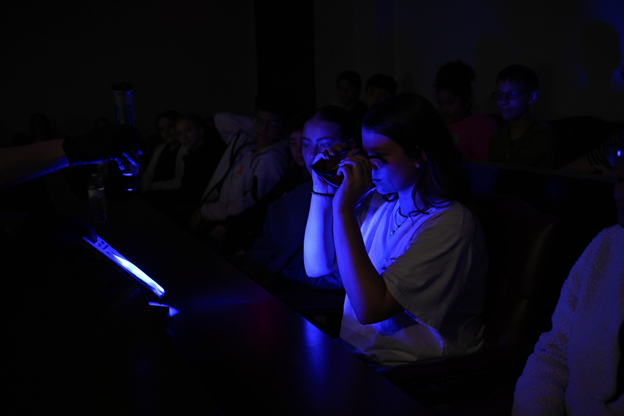 Makyna, Altus Junior High School student, puts on specialized glasses to see fingerprints under an ultraviolet light during Law Day at Altus Air Force Base, Oklahoma, May 1, 2025. Altus Junior High students had the opportunity to step into the shoes of investigators to learn how evidence is collected, analyzed, and used to build a case in court. (U.S. Air Force photo by Senior Airman Kari Degraffenreed)
