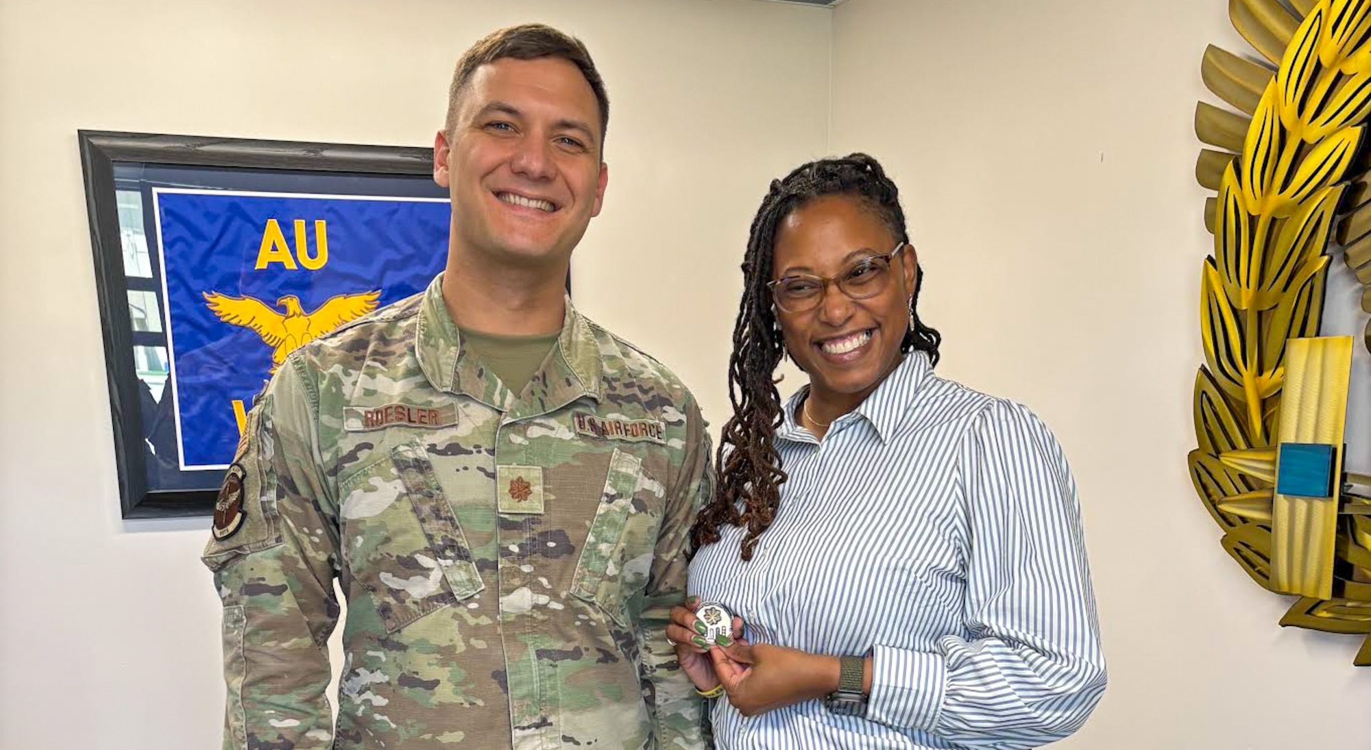 U.S. Air Force Maj. Nathaniel Roesler, Warrant Officer Training School commandant, and Sonja M. Simmons, Holm Center chief of protocol, pose for a photo at Maxwell Air Force Base, Alabama, April 8, 2025.