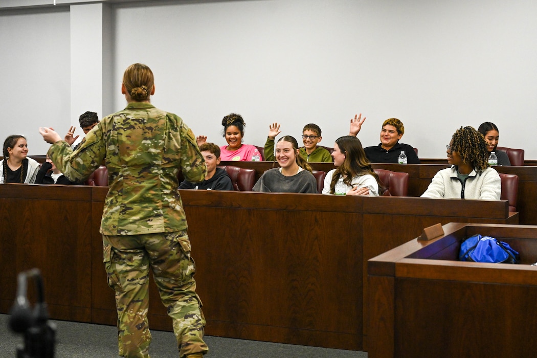 U.S. Air Force Airman 1st Class Shiaslynn Garcia, 97th Air Mobility Wing Judge Advocate (JA) military justice paralegal, is sworn-in by Ronan, Altus Junior High School student, during a mock trial during Law Day at Altus Air Force Base, Oklahoma, May 1, 2025. Students took turns acting as attorneys and trial lawyers while receiving advice on what to do from JA team members. (U.S. Air Force photo Senior Airman Kari Degraffenreed)