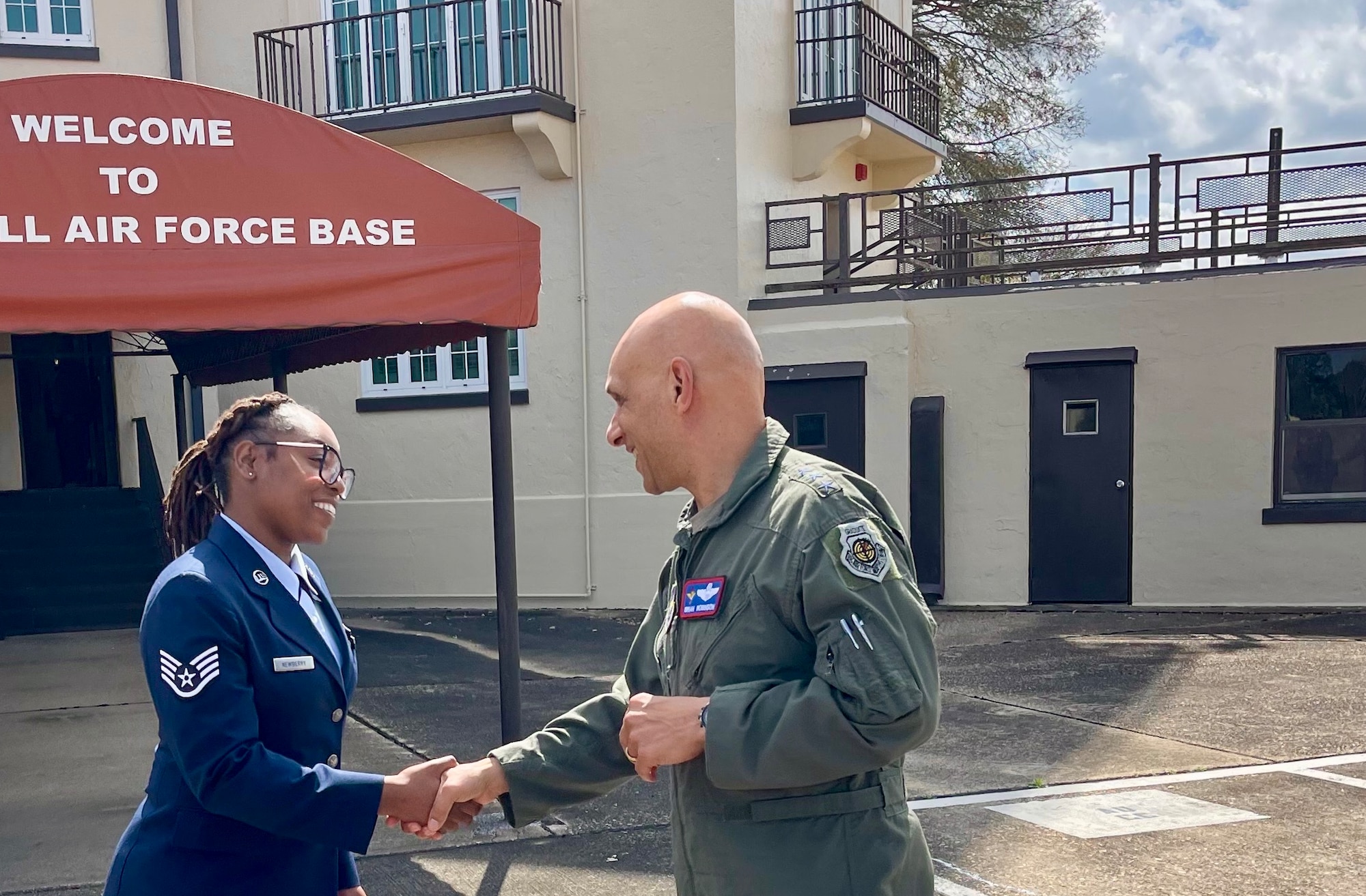 U.S. Air Force Lt. Gen. Brian S. Robinson, Air Education and Training Command commander, shakes hands with U.S. Air Force Staff Sgt. Jamilla Newberry, Holm Center protocol noncommissioned officer in charge, at Maxwell Air Force Base, Alabama, March 14, 2025.