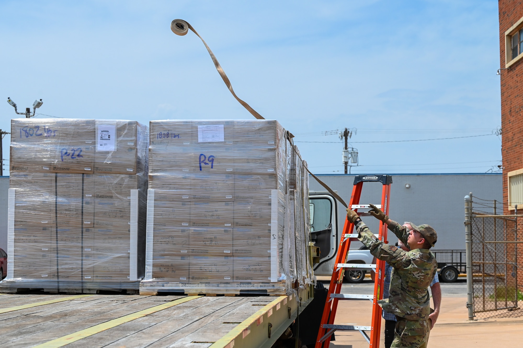 U.S. Air Force Senior Airman Joshua Sandoval, 7th Logistics Readiness Squadron ground transportation operator, tosses a tie down strap to prepare food supplies for transportation in support of the Denton Program to Dyess Air Force Base in Abilene, Texas, April 28, 2025. The Denton Program is a Department of Defense transportation program that moves humanitarian cargo, donated by U.S. based non-governmental organizations to developing nations to ease human suffering. (U.S. Air Force photo by Airman 1st Class Adrien Tran)