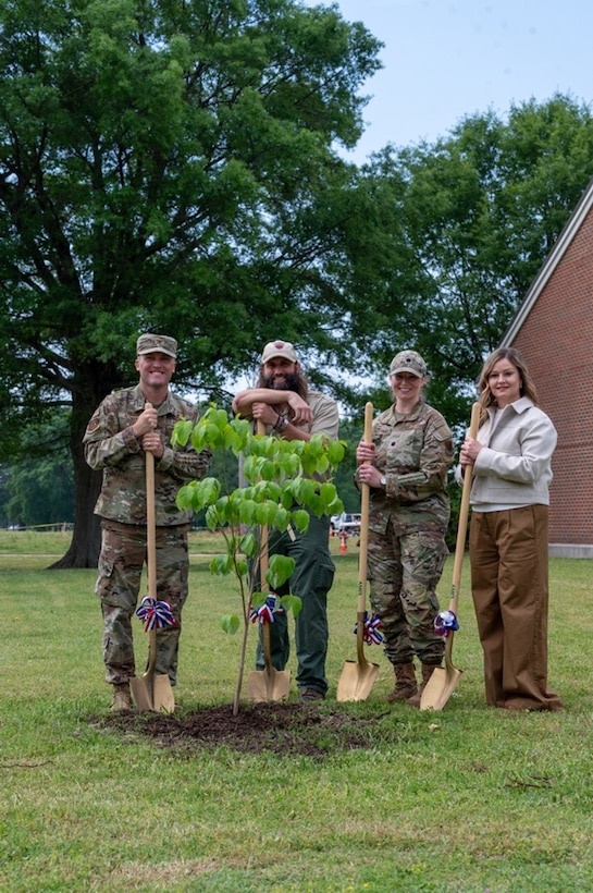 Airmen and civilians pose for a photo while leaning on shovels. (U.S. Air Force photo by Airman 1st Class Donnell Ramsey)
