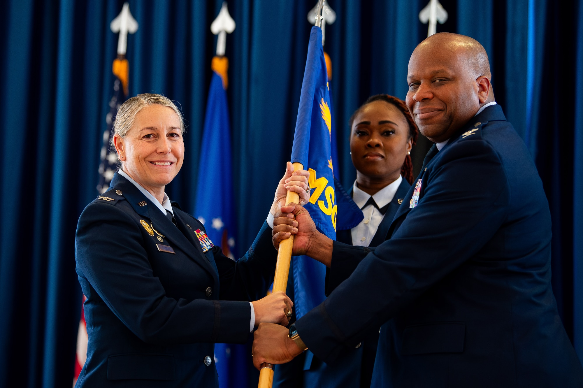 Col. Cheo Stallworth, 10th Mission Support Group commander, passes the 10th MSG guidon to Col. Amy Glisson, 10th Air Base Wing commander, during an inactivation ceremony at the U.S. Air Force Academy, Colo., May 1, 2025. The 10th MSG was officially inactivated after 23 years of service at the Academy, overseeing critical base functions such as engineering, law enforcement, logistics, personnel services, communications, and contracting. (U.S. Air Force photo by Dylan Smith)