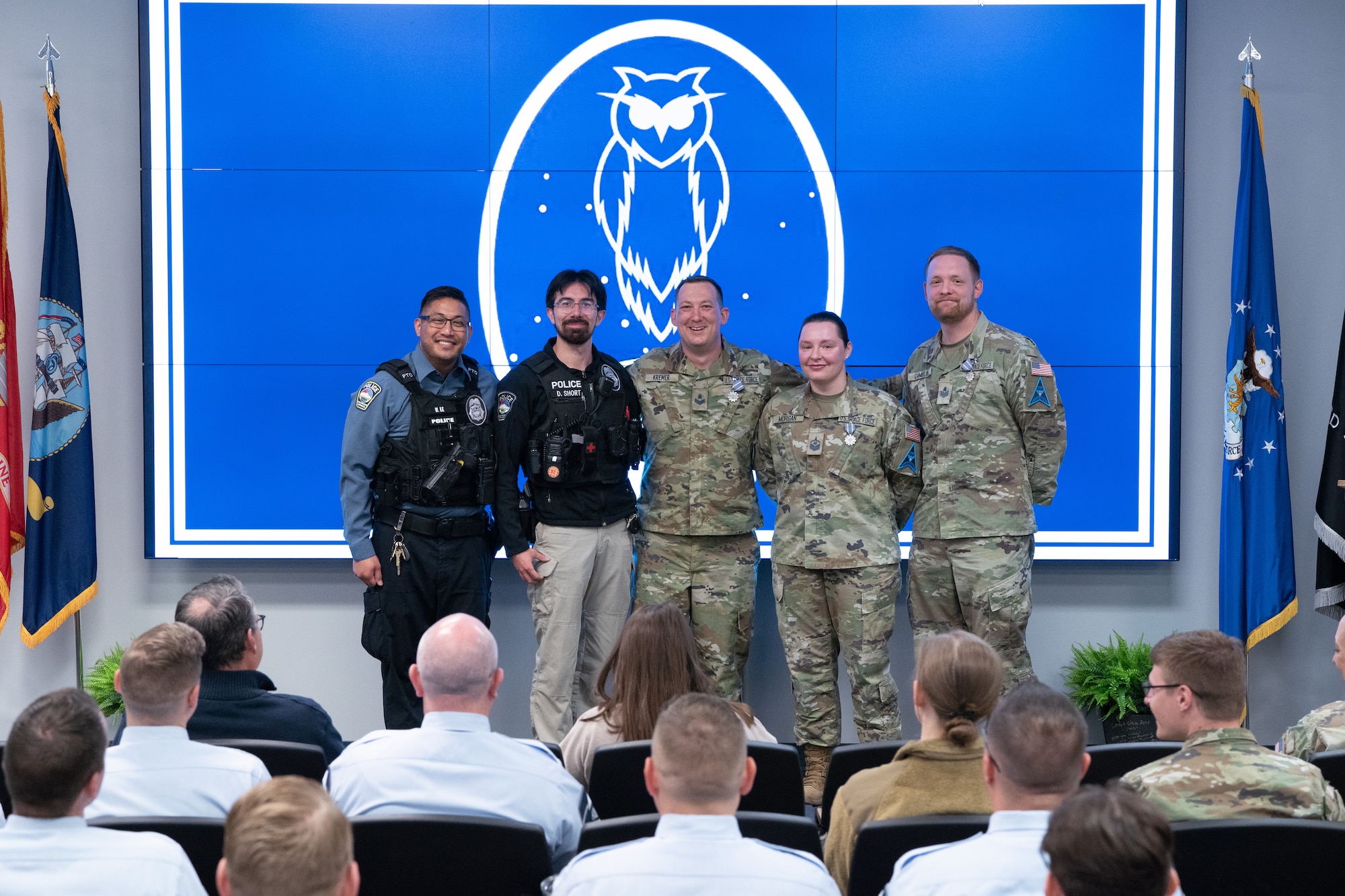 Two police officers posing for photo with Guardians